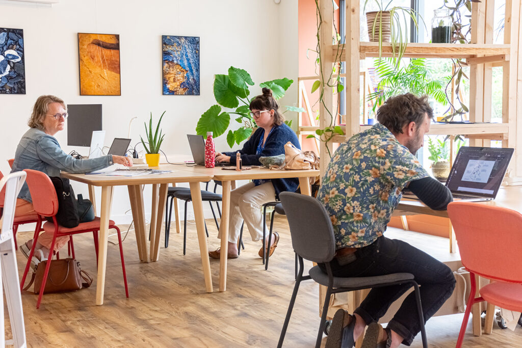 des coworkers travaillent dans la grande salle de la serre